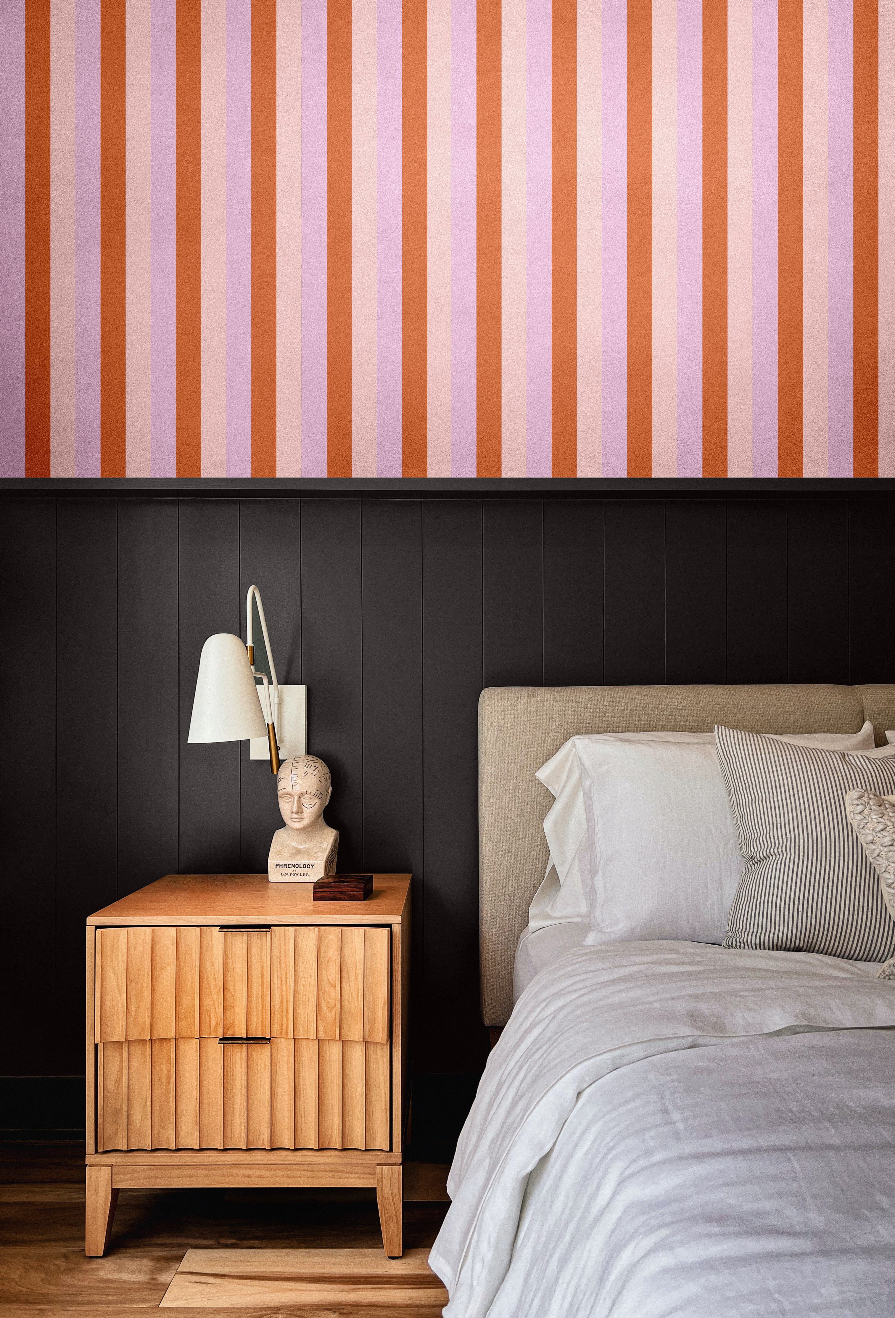Moody modern bedroom with half-wall Taffy wallpaper above black paneling