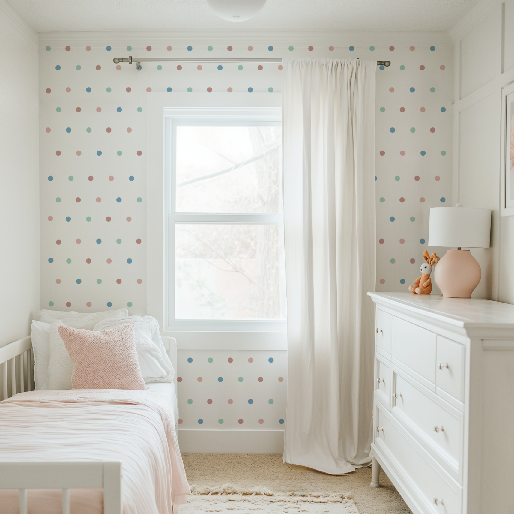 Custom color peel and stick wall dots decorating a bright nursery around a window with pastel blue, mint and blush polka dots.