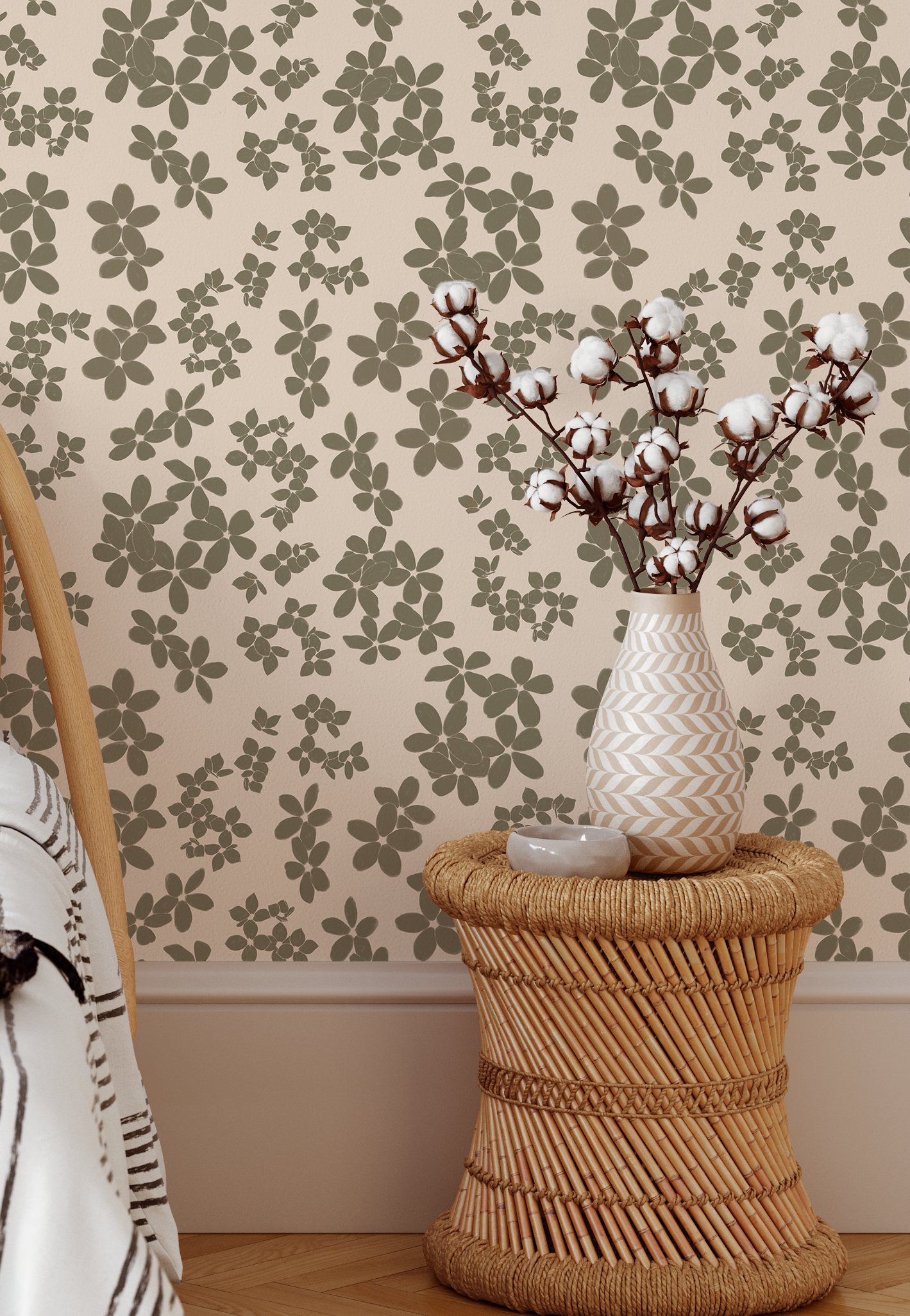 Vase with cotton branches on a woven stool against floral wallpaper
