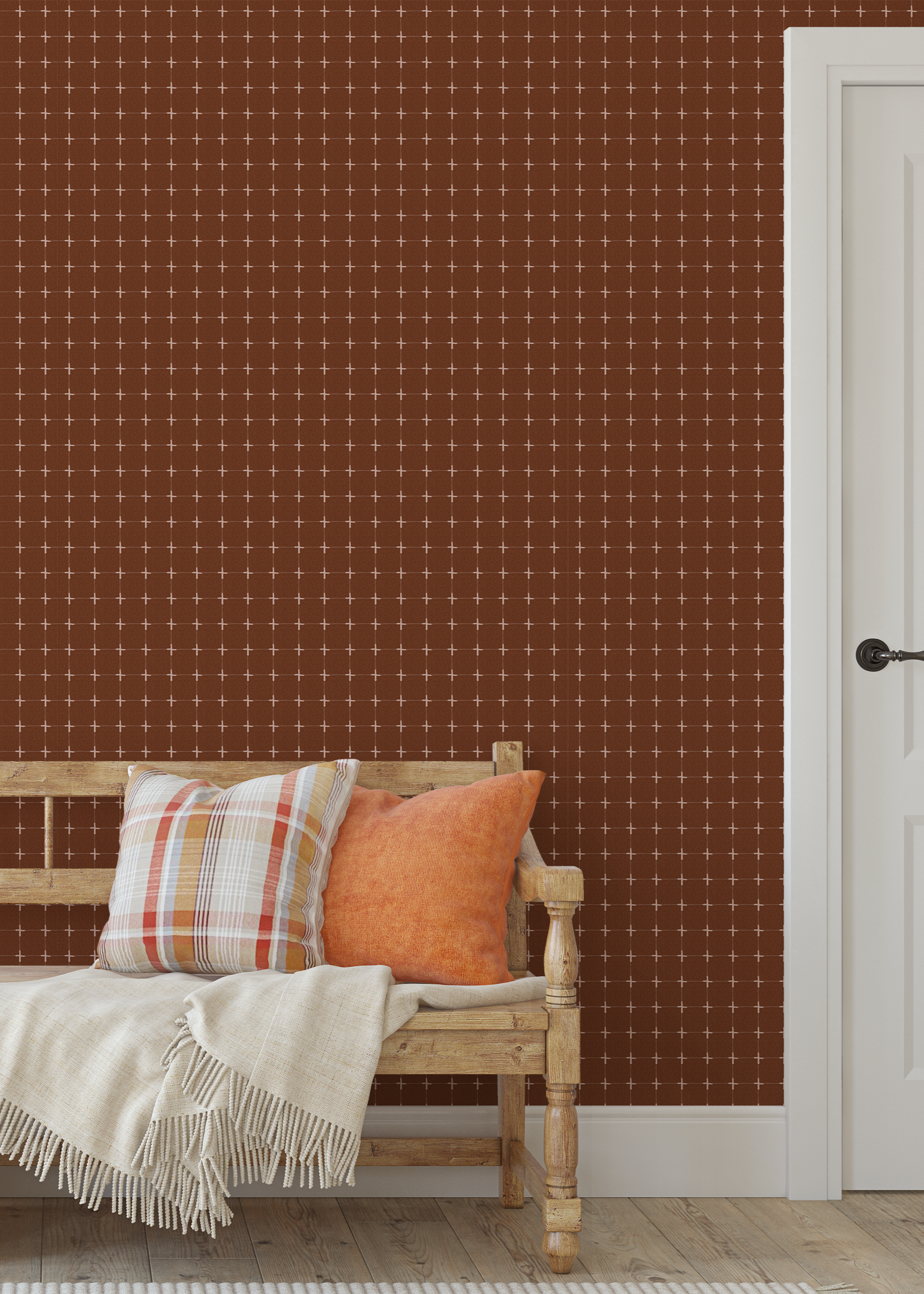 Warm brown grid wallpaper behind a rustic wood bench with orange and plaid pillows