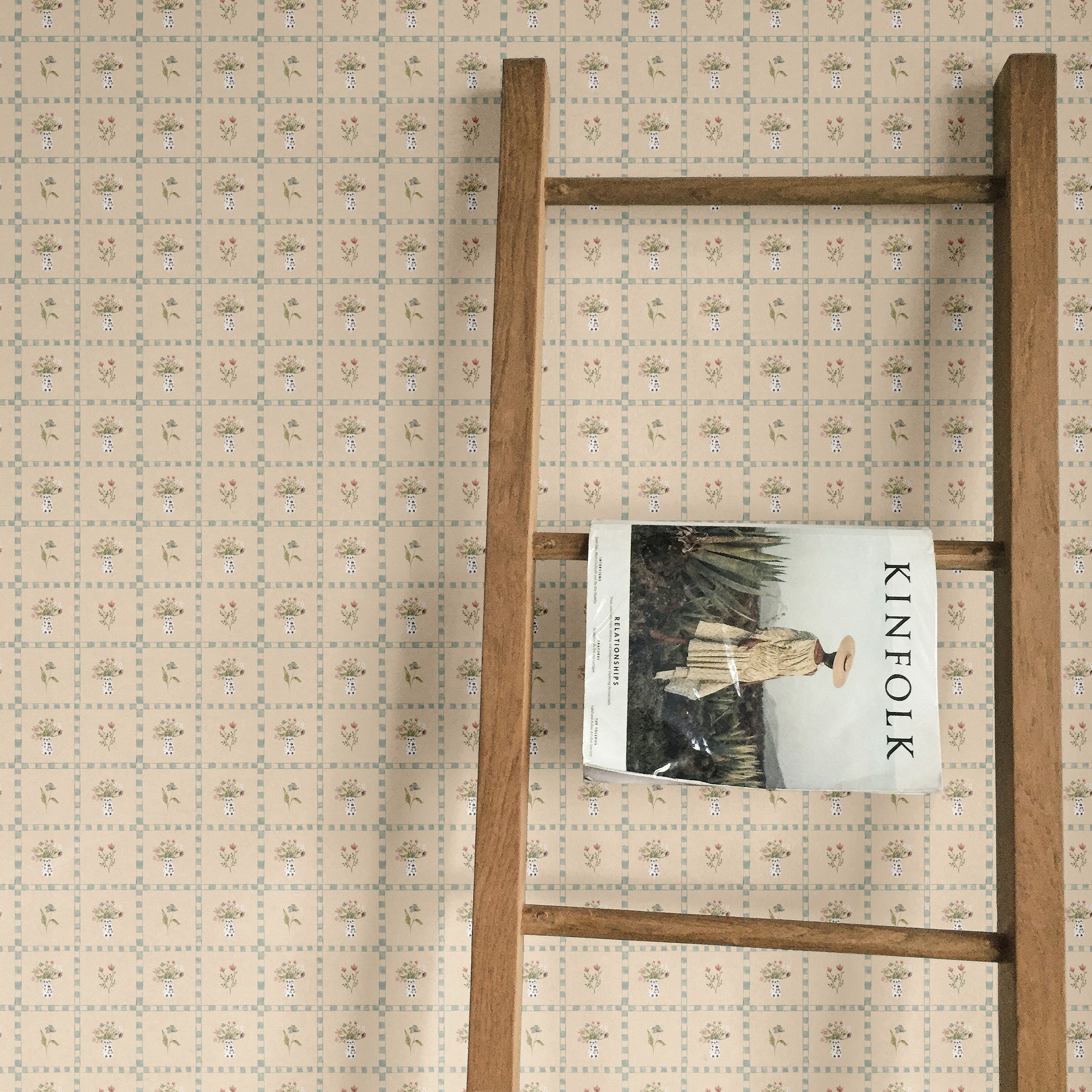 Rustic cottagecore wallpaper with delicate floral patterns, paired with a wooden ladder and vintage magazine for cozy home decor