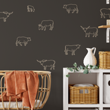 Close-up of nursery with cow decals on dark brown wall and wicker storage baskets