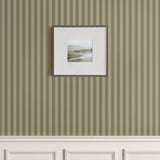 Classic vertical green stripe wallpaper with beige wainscoting and framed coastal photo