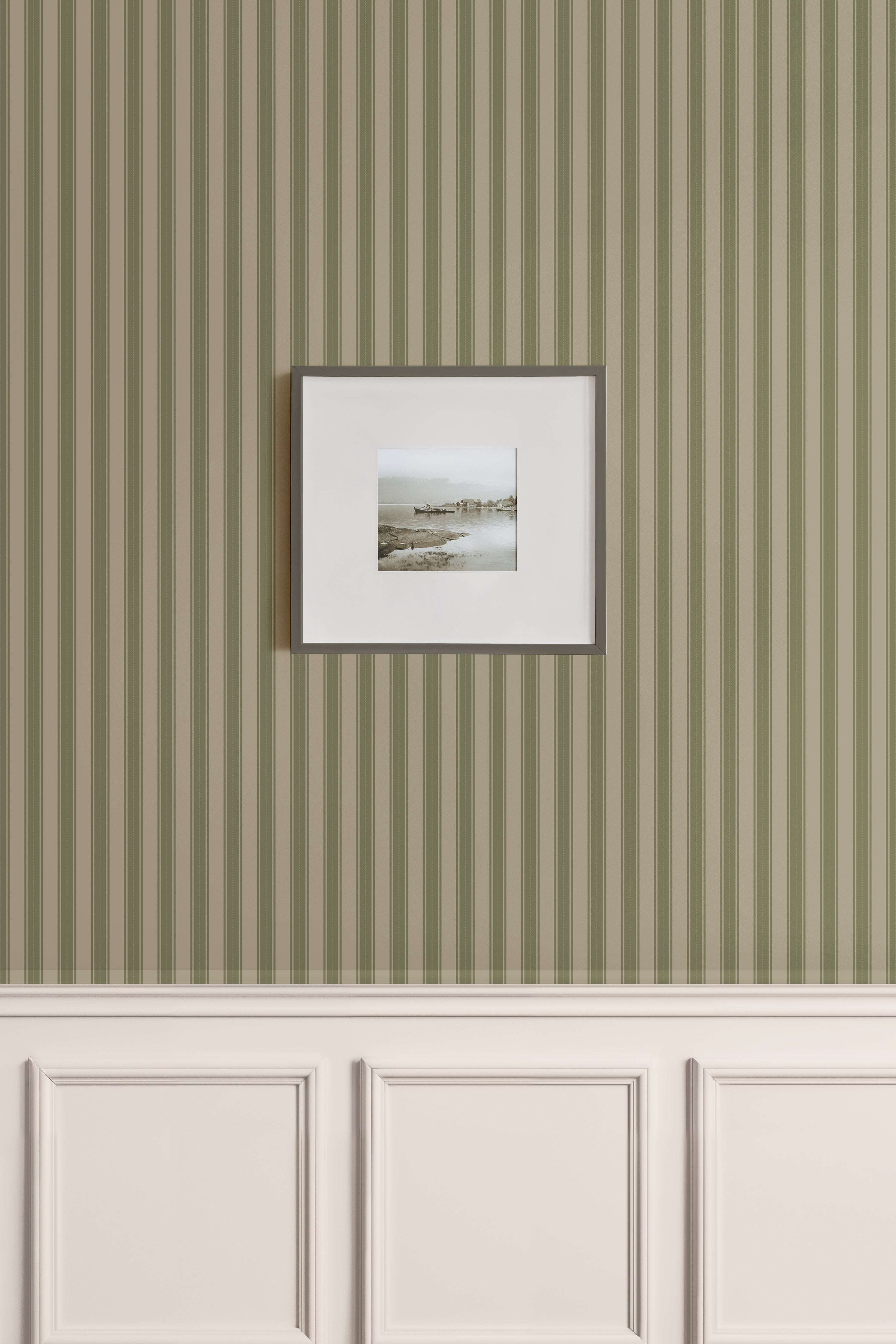 Classic vertical green stripe wallpaper with beige wainscoting and framed coastal photo