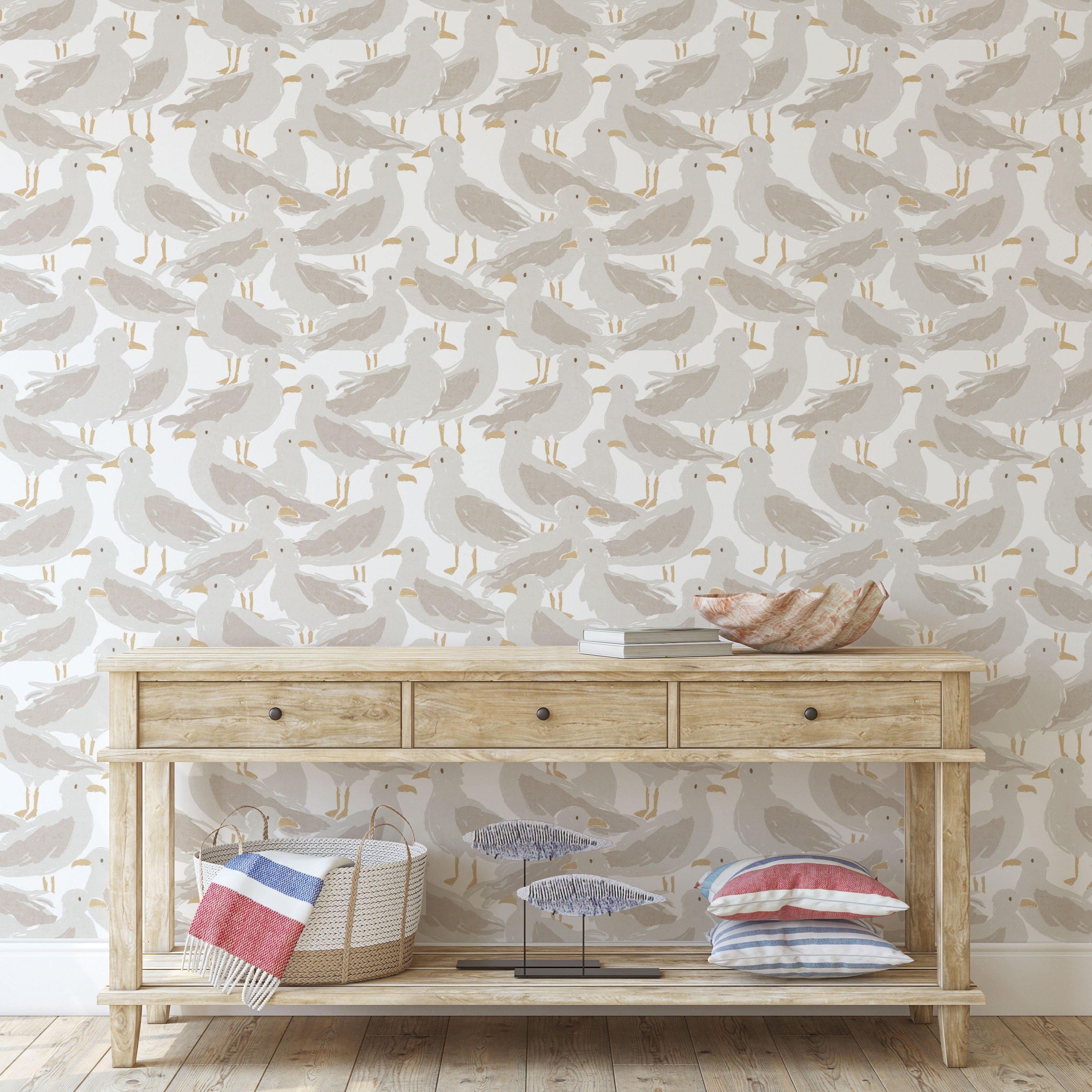 Wooden console table with decorative items against a wallpapered wall with bird seagull pattern