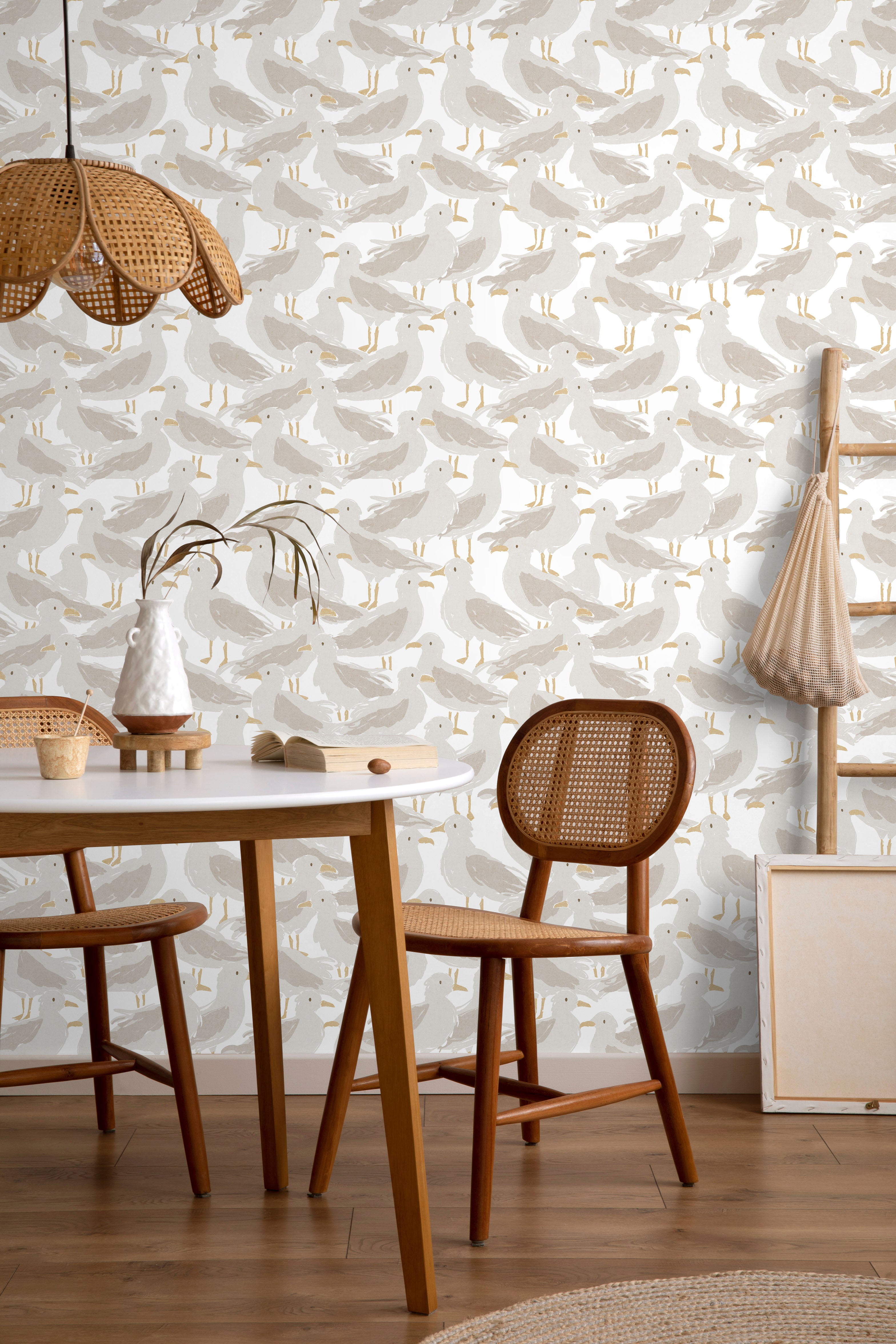 Dining room with Seagull patterned wallpaper, wooden table, and chairs.