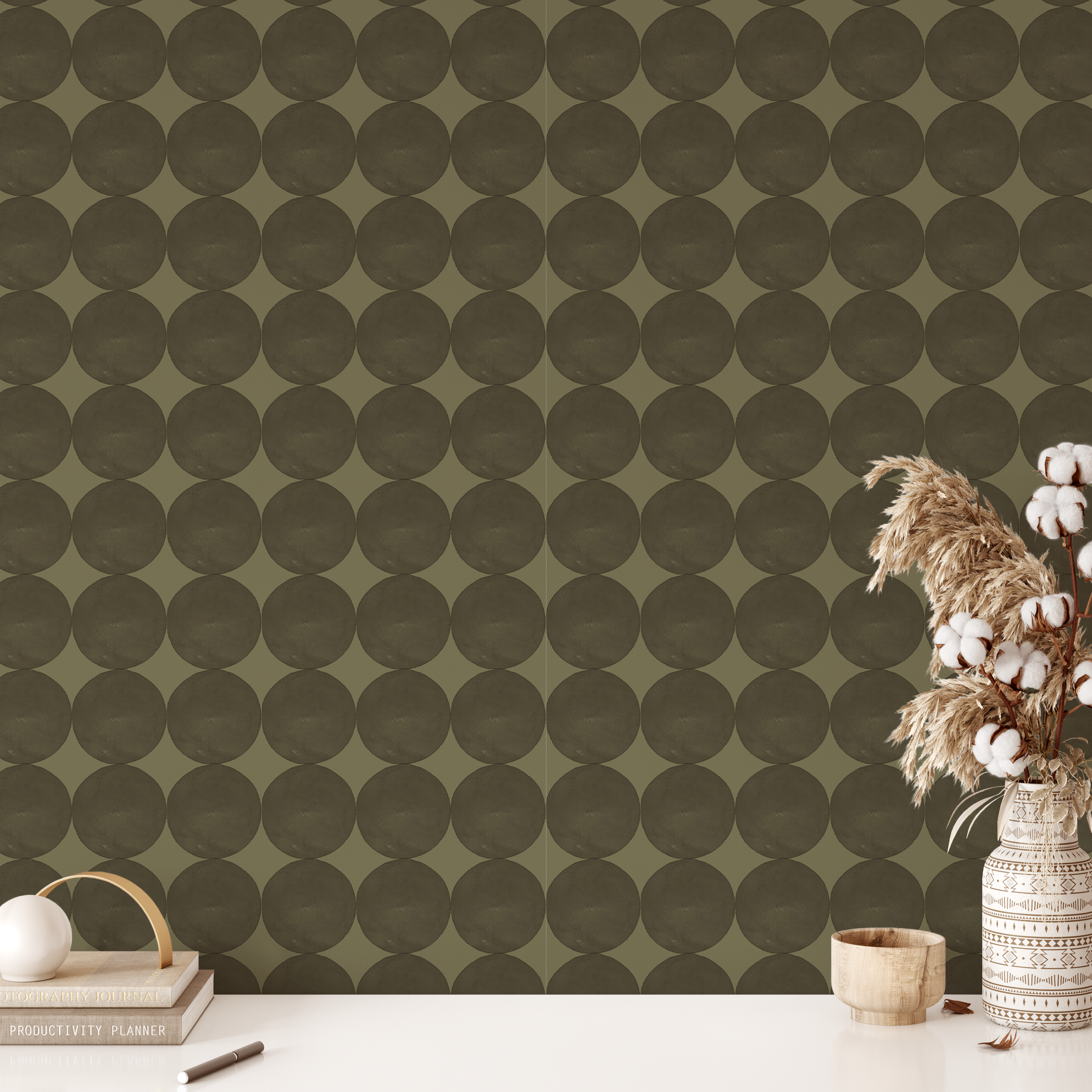 Olive green mod dot wallpaper styled with neutral desk decor and cotton stems
