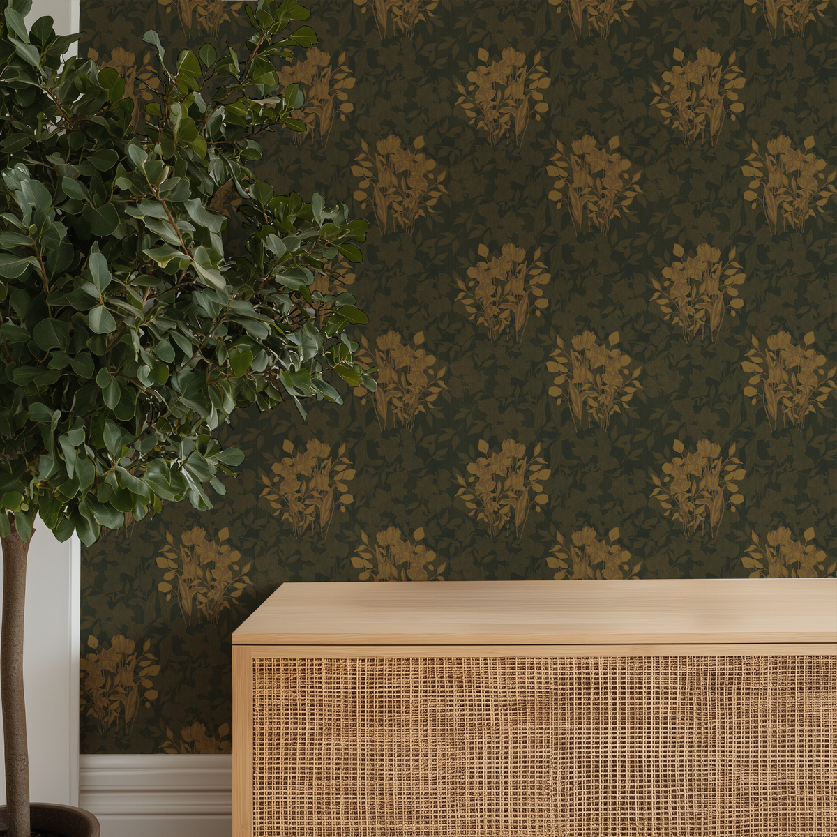Mustard Leaf damask wallpaper with a repeating gold floral pattern, shown in a styled room setting behind a light wood cabinet and next to a potted green tree.