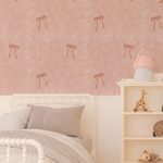 Soft pink bedroom featuring Pink Bow Vintage Wallpaper with floral pattern, white spindle bed, and neutral bedding.