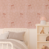 Soft pink bedroom featuring Pink Bow Vintage Wallpaper with floral pattern, white spindle bed, and neutral bedding.