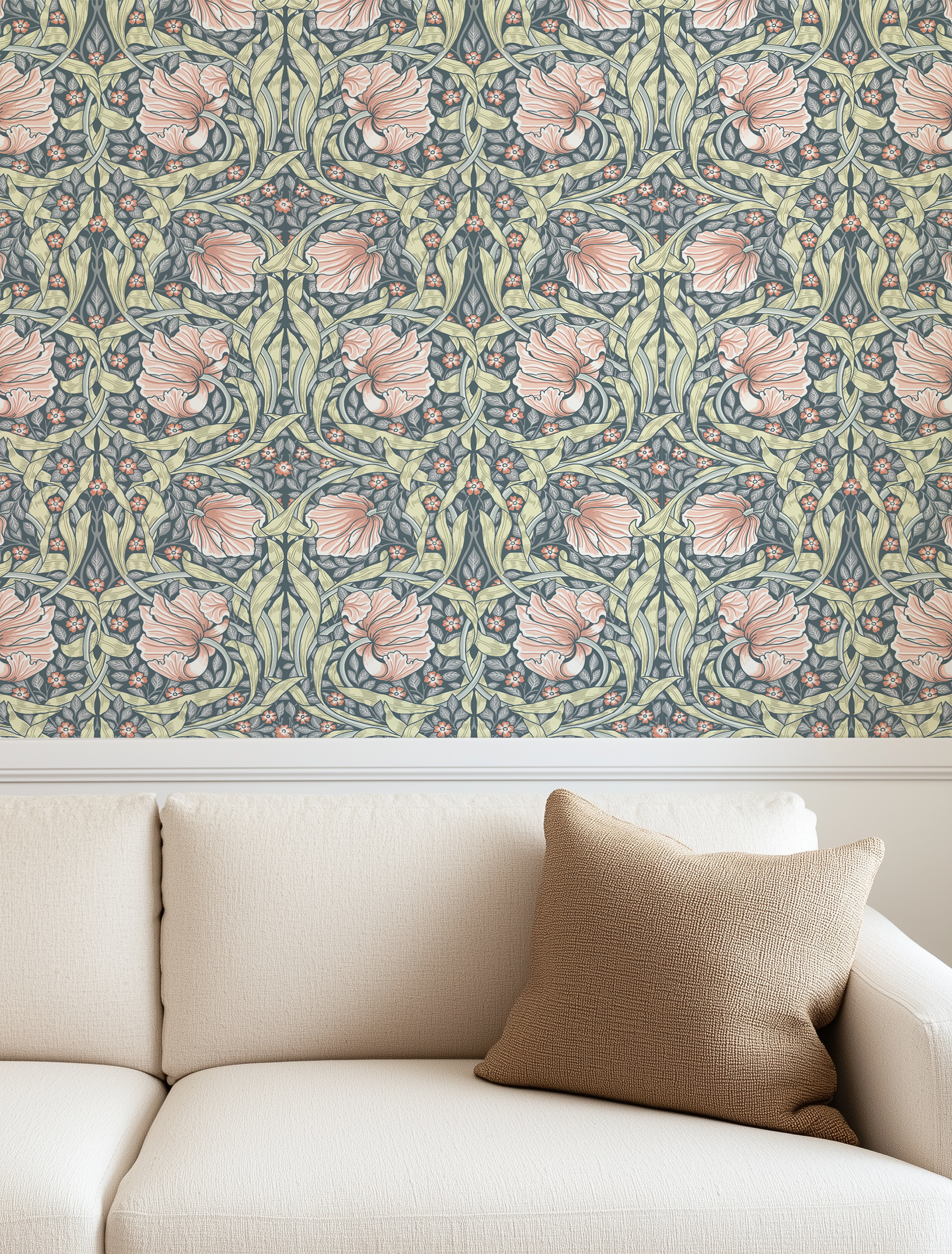 A styled interior scene showing a cream sofa with a tan throw pillow beneath a wall covered in an intricate floral wallpaper pattern in muted blue, sage green, and blush pink.