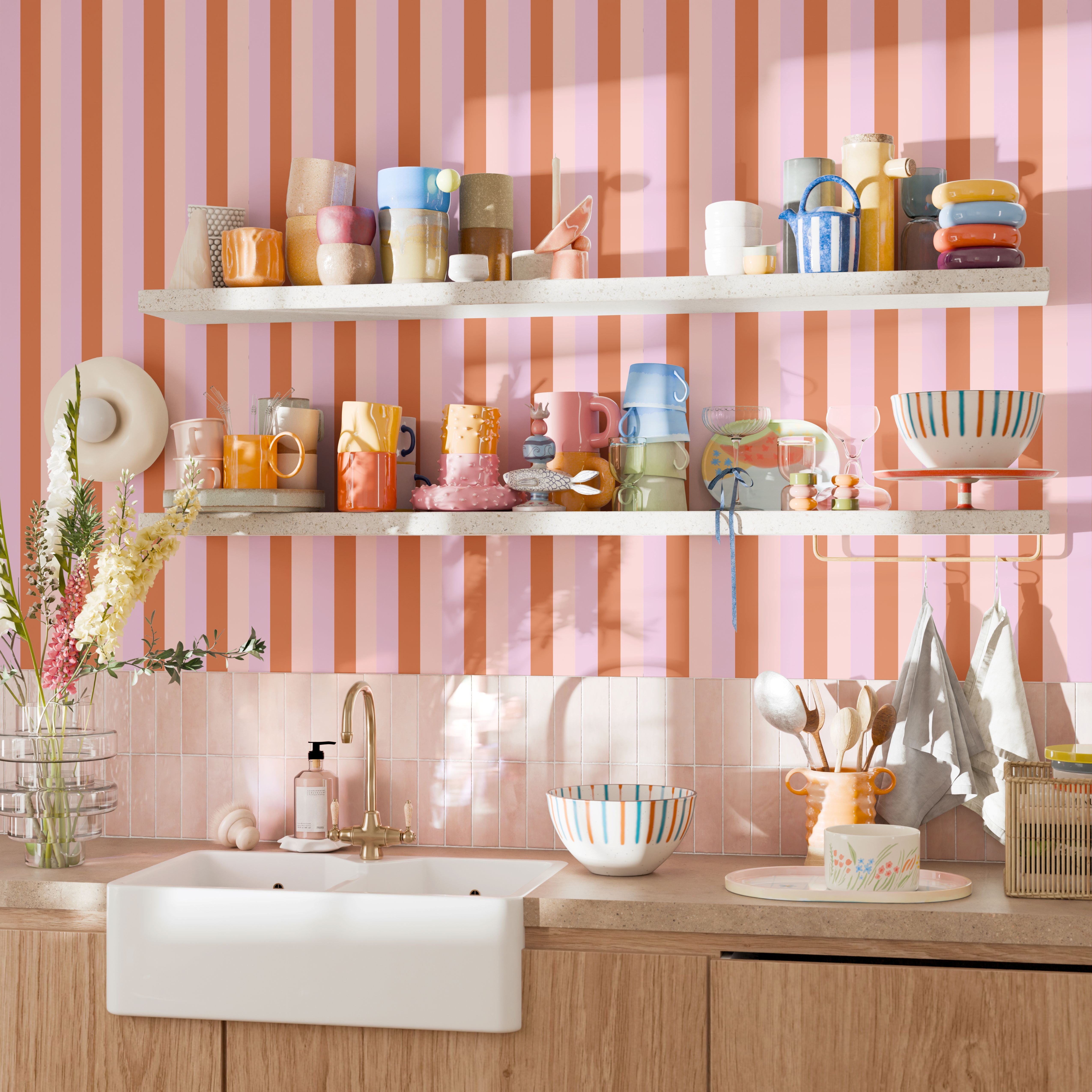 Colorful kitchen with Taffy stripe wallpaper behind open shelving and mugs