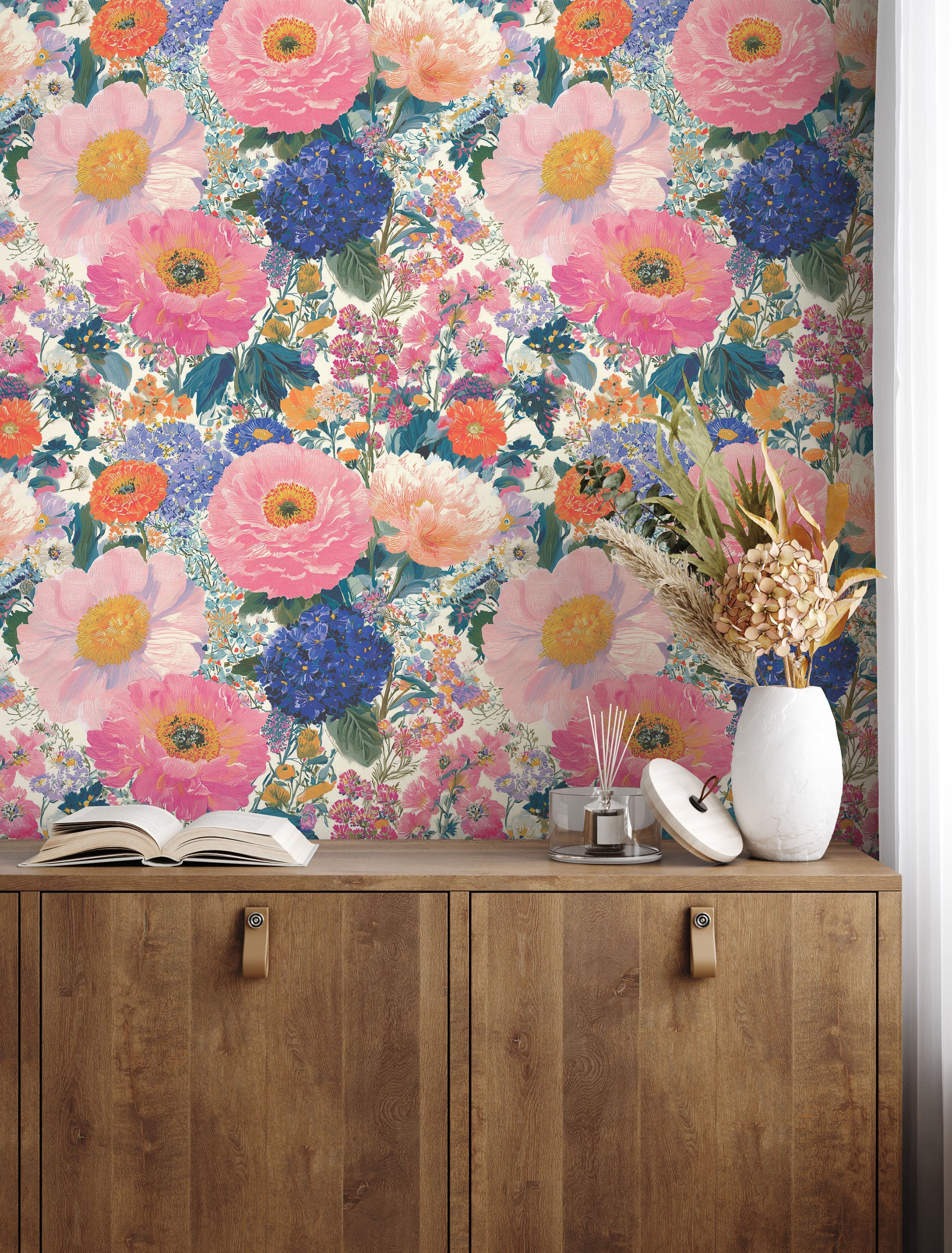Colorful floral wallpaper with oversized pink peonies, blue hydrangeas and orange blooms in a maximalist botanical pattern