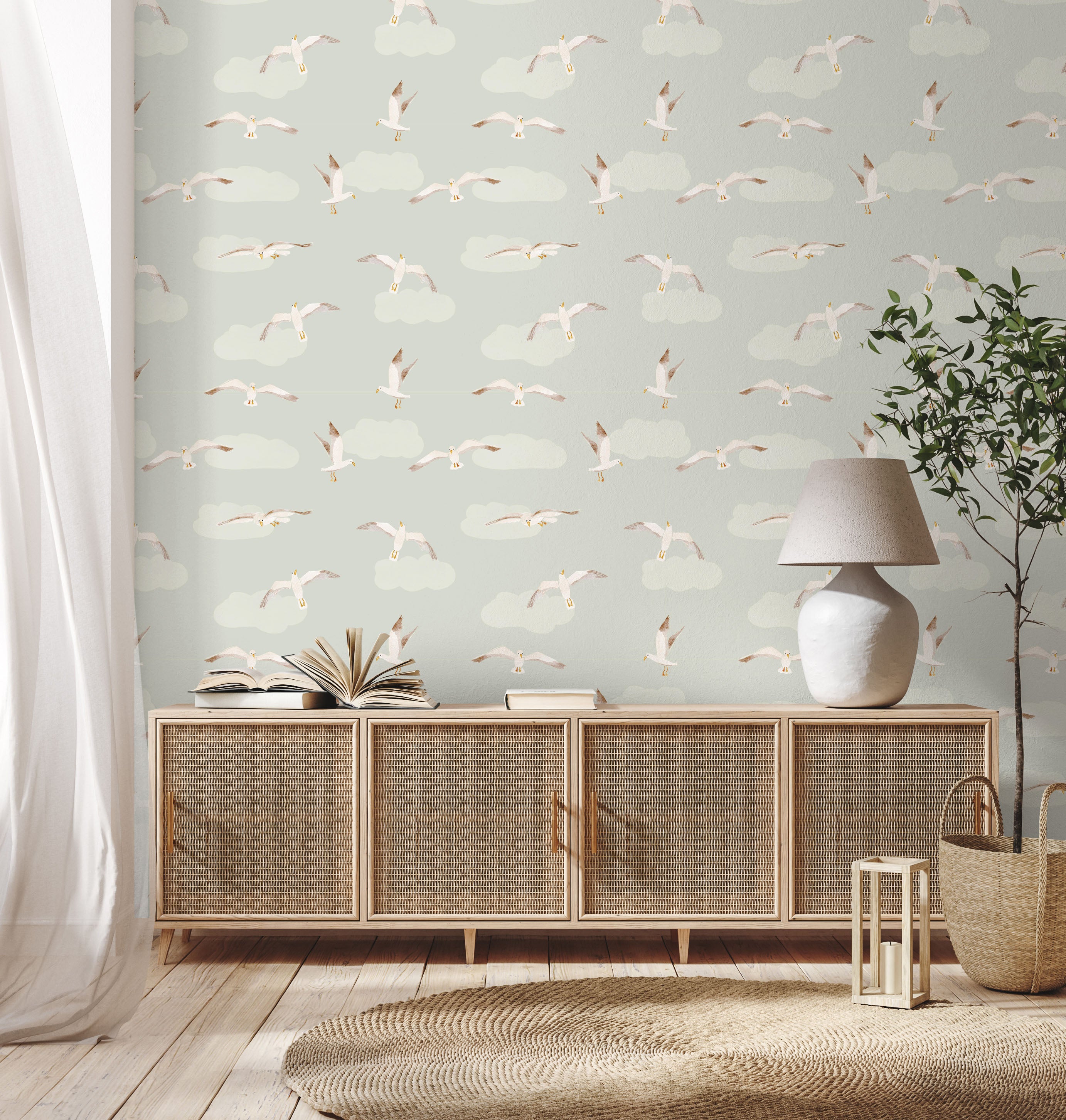 Room interior with wicker cabinet, lamp, and books against a wallpapered wall with bird pattern.