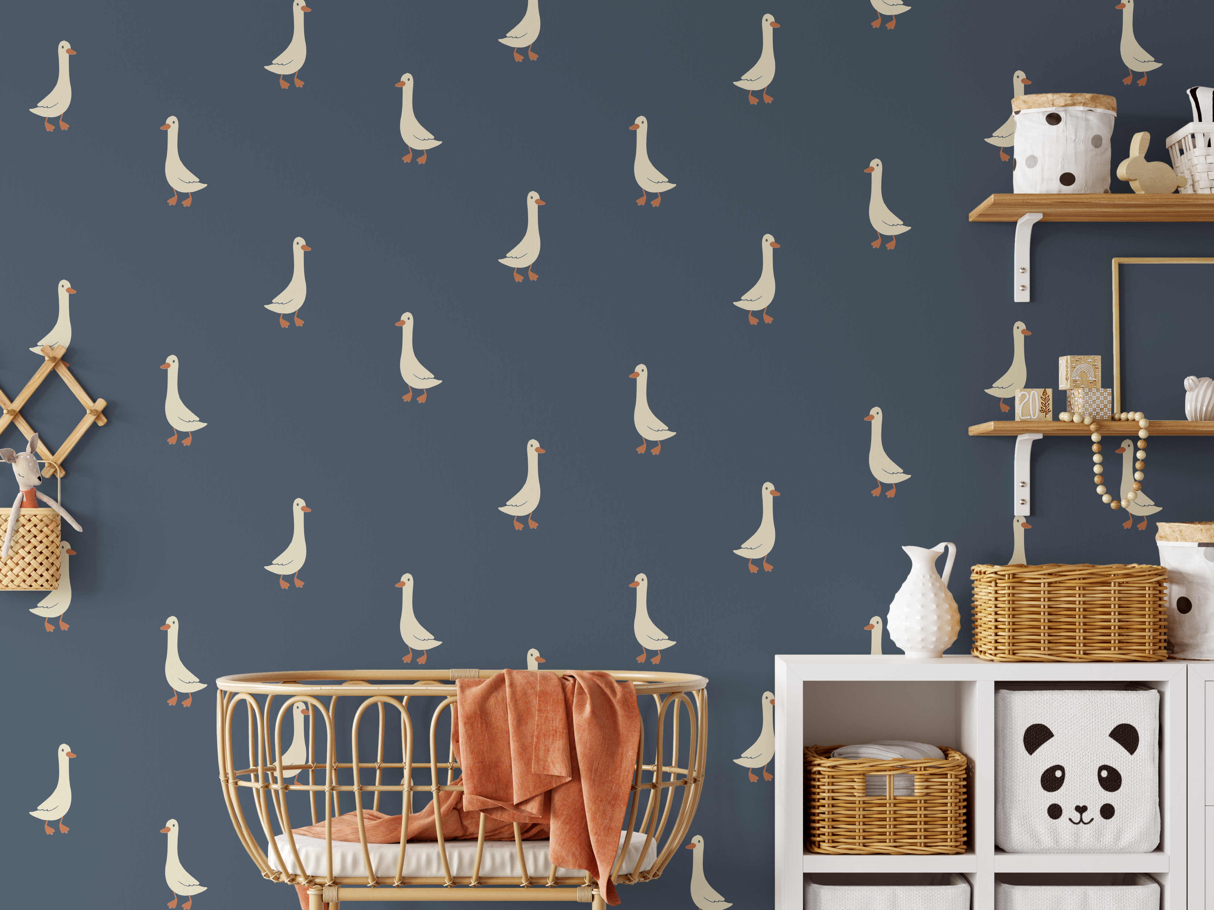 Goose wall decals on navy blue wall with rattan crib, wicker baskets, and nursery storage.