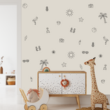 Beach-themed nursery wall with outline decals including beach ball, camera, drink, sun, and pineapple