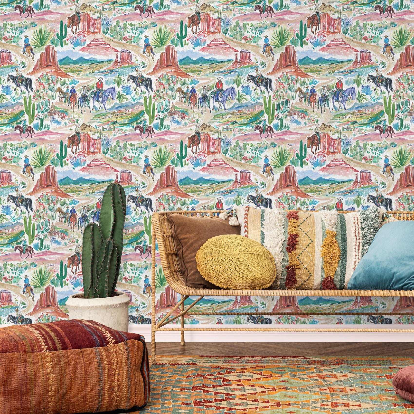 Southwestern cowboy wallpaper styled with rattan bench, cactus plant, and colorful boho pillows