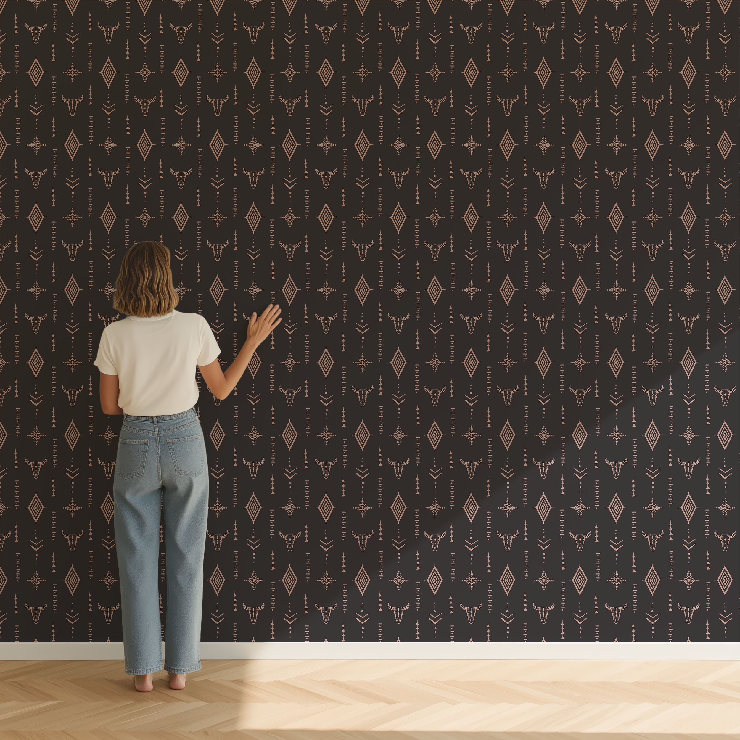 Woman viewing dark western wallpaper featuring longhorn skulls, geometric diamonds and boho tribal motifs on a feature wall.