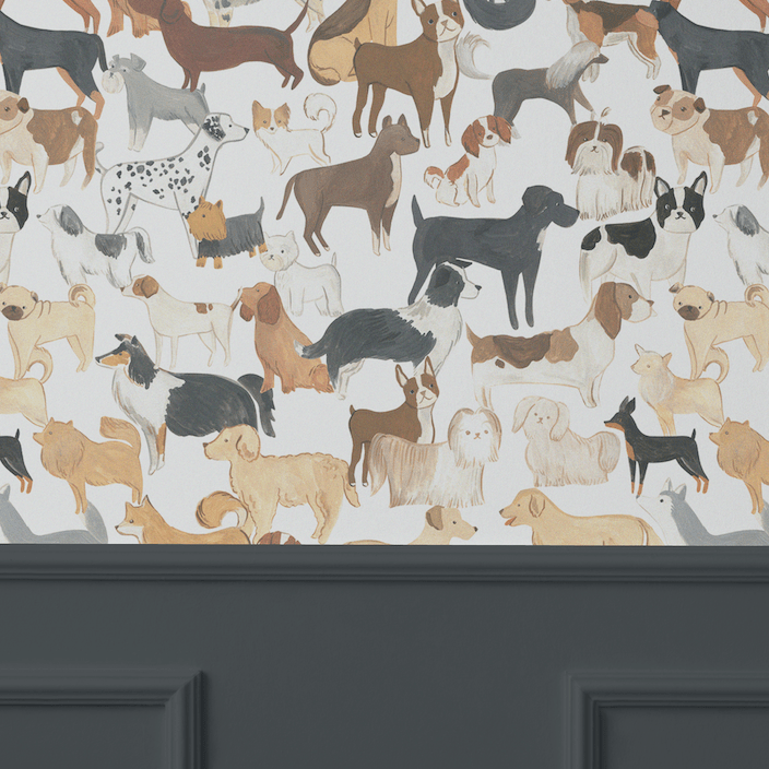 An elegant room with dark grey paneling halfway up the wall, topped with wallpaper displaying a lively assortment of painted dog illustrations in a repeat pattern.