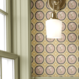 A sage green panel wall with brass sconce lighting, complemented by mustard yellow floral scalloped wallpaper for a sophisticated farmhouse-inspired look.