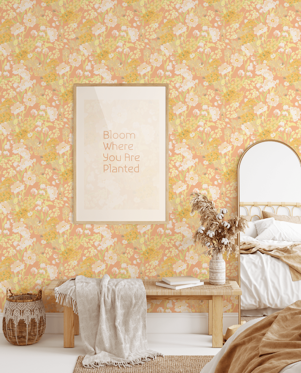 A cozy bedroom scene showcasing the Happy Floral peel and stick wallpaper on the walls. The room includes a wooden bench with a throw blanket, a woven basket, a bed with neutral bedding, and a framed picture that reads "Bloom Where You Are Planted