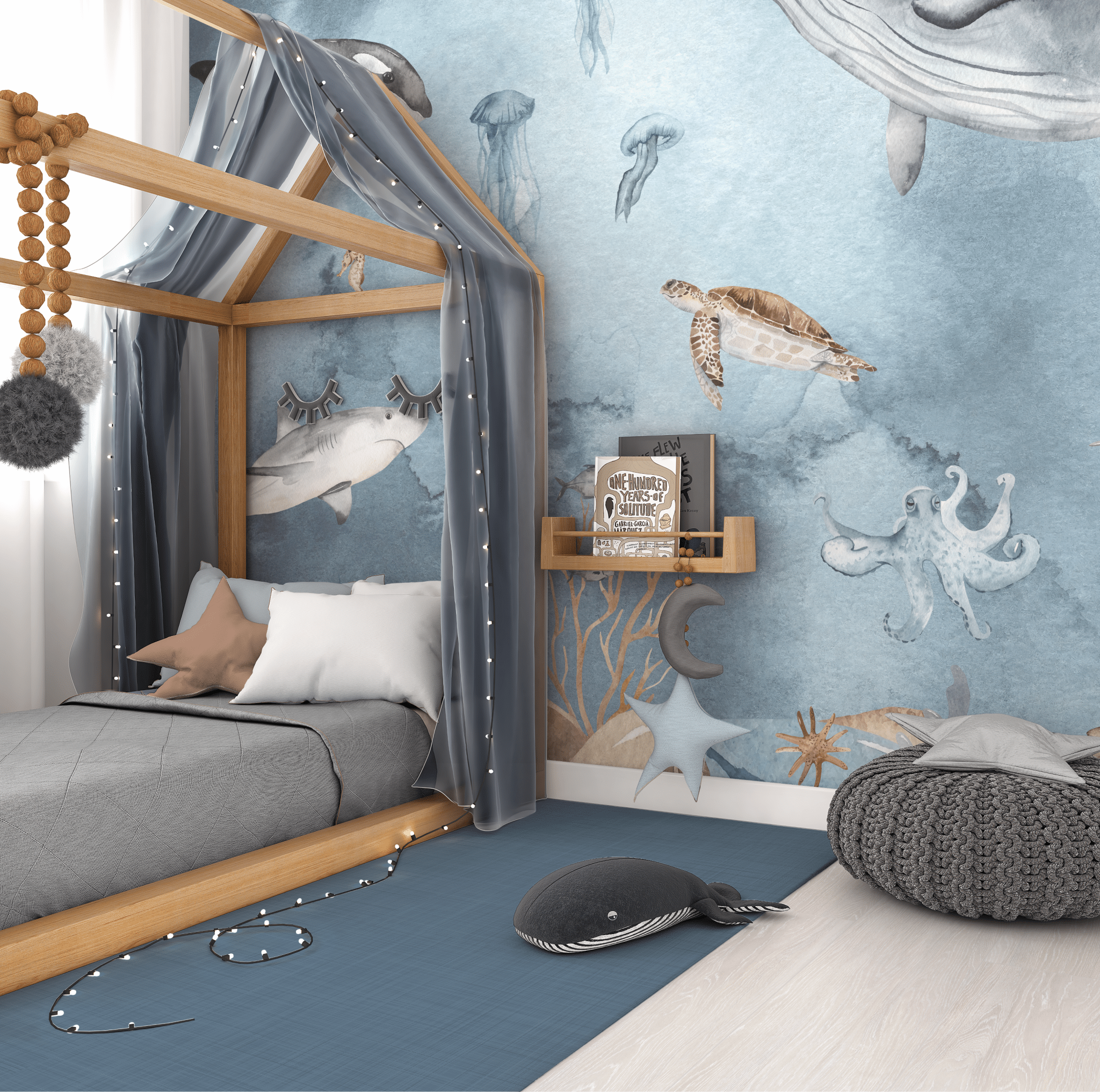 Cozy boy's bedroom with a canopy bed and an expansive undersea wall mural. The mural depicts lifelike illustrations of marine life such as a hammerhead shark, jellyfish, sea turtle, and a playful octopus. The bed is adorned with a grey bedspread, starry grey canopy, and a cushioned pouf nearby, creating an inviting ocean-themed nursery atmosphere