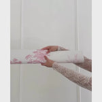 Unrolling pink toile wallpaper with ballerinas, trees in the background.
