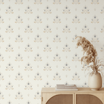 Entryway featuring elegant regal floral wallpaper with intricate blue and gold patterns, a wooden cabinet, and a vase of dried pampas grass