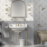 Traditional bathroom with regal floral wallpaper in blue and gold patterns, featuring a vintage sink with brass fixtures, a matching bathtub, and elegant lighting