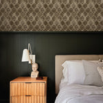 wallpaper above green wall treatment in bedroom with bed and side table