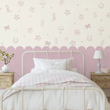 Mauve seaside cowgirl decals above a scalloped pink wall in a vintage-style bedroom