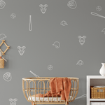 Baseball outline decals on a grey wall in a stylish nursery setup, with bat, glove, and ball designs in white.