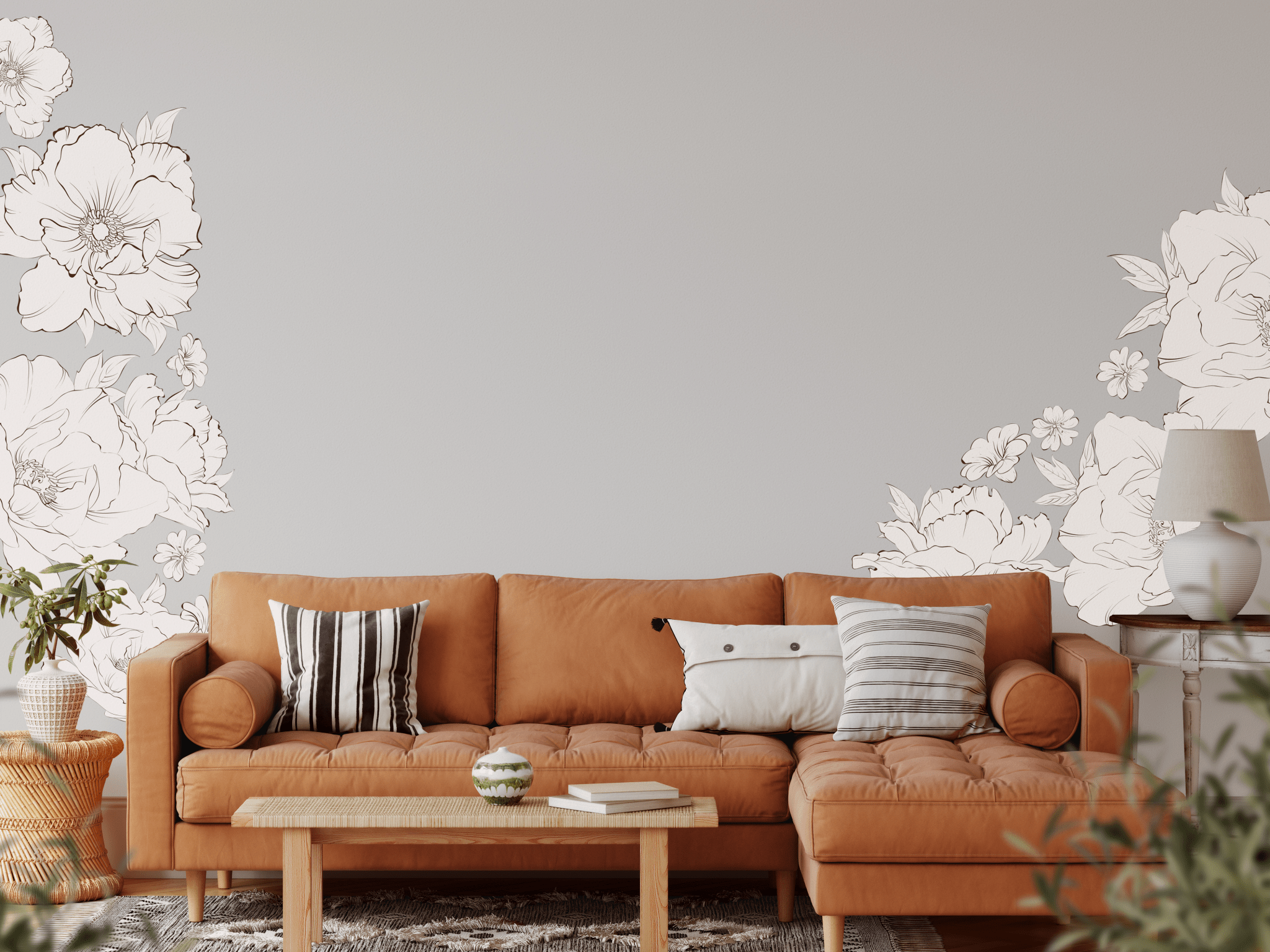 Living room with boho-style decor featuring large, detailed peony wall decals in soft, neutral tones. The decals frame a brown leather sectional, adding a touch of elegance to the cozy space