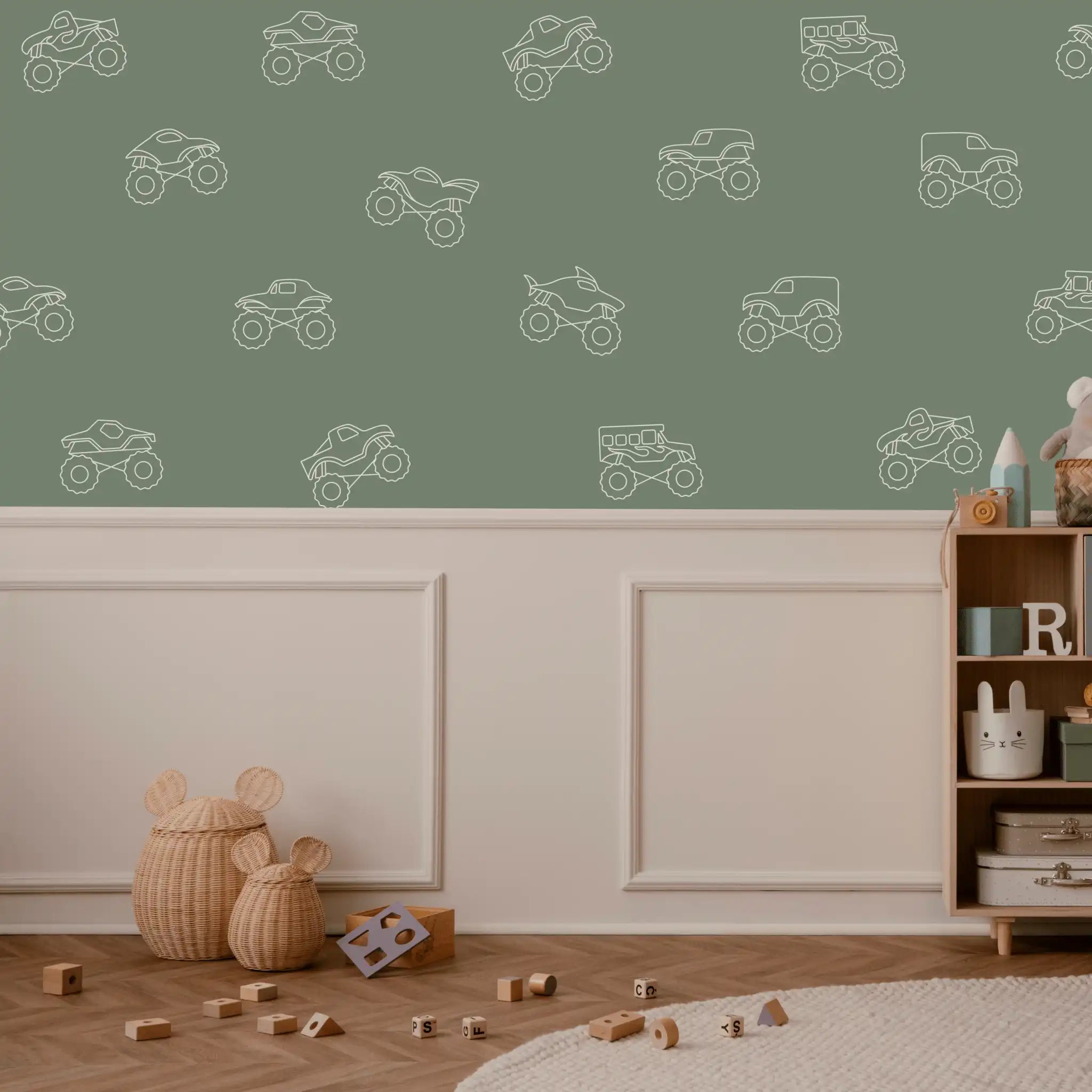 Monster truck wall decals in white outline on a sage green wall in a neutral kids’ room with soft toy storage and wood toy blocks
