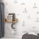 Sailboat and ocean wave wall decals in a cozy reading nook with a moon and star mobile