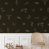 Dark western-style room with white outline decals of cowboy elements like horseshoes, hats, cacti, and spurs