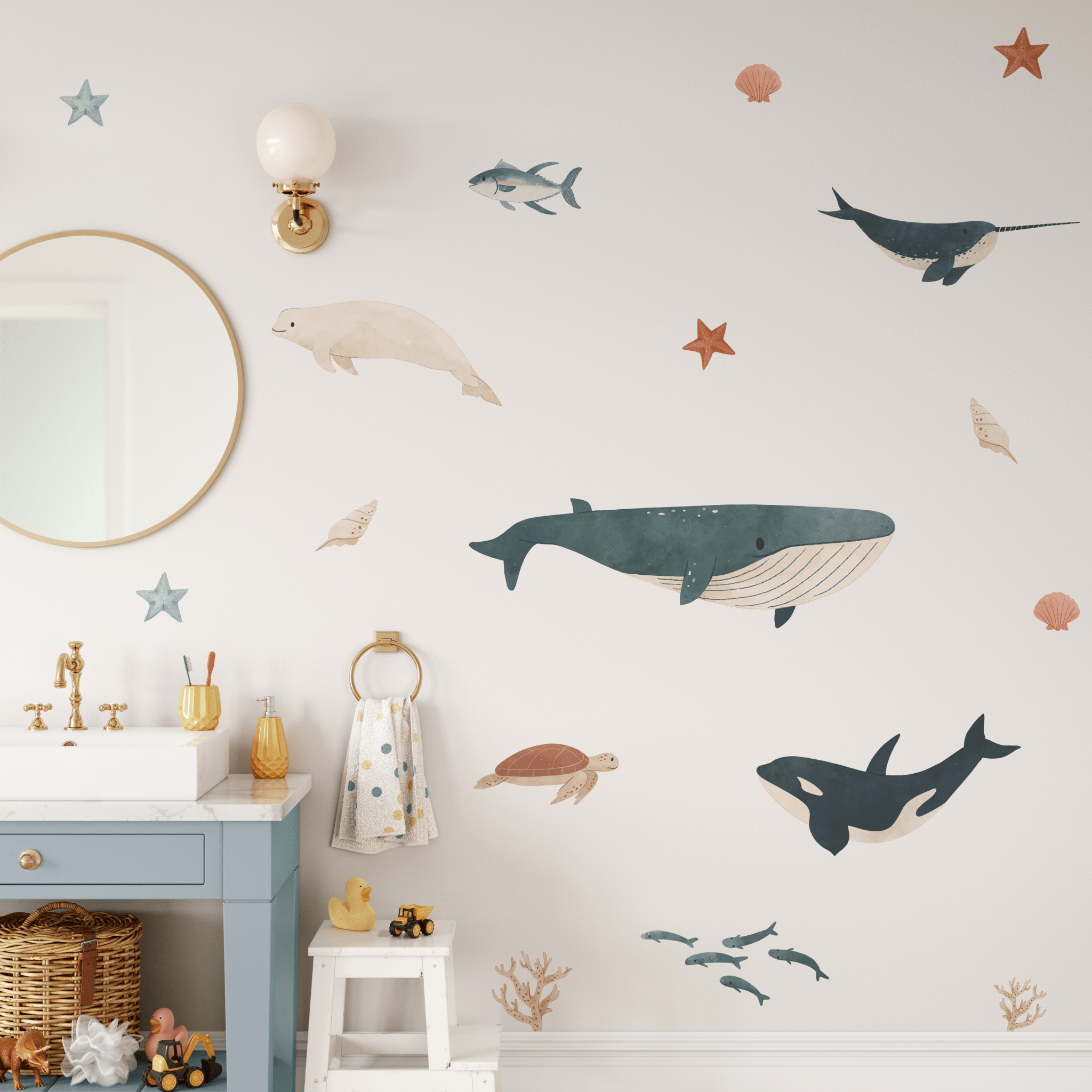 Nursery bathroom with sea animal stickers; a whimsical touch to the white walls, paired with a blue vanity and playful accents.