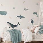 Cozy nursery with gentle ocean wall decals, featuring a white crib with soft textiles and a starry canopy for a peaceful bedtime atmosphere.