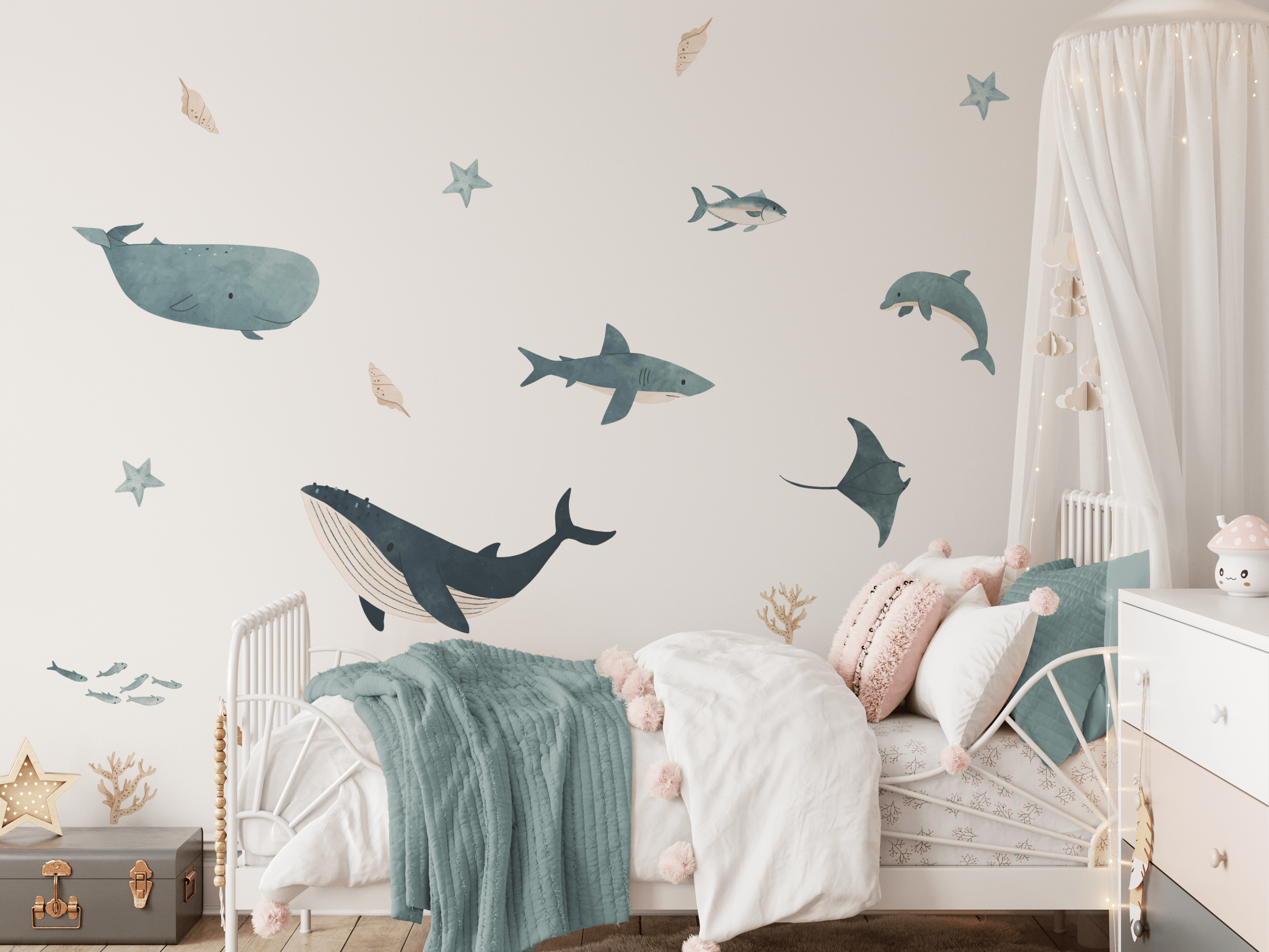 Cozy nursery with gentle ocean wall decals, featuring a white crib with soft textiles and a starry canopy for a peaceful bedtime atmosphere.