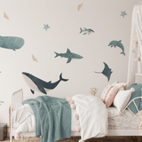Cozy nursery with gentle ocean wall decals, featuring a white crib with soft textiles and a starry canopy for a peaceful bedtime atmosphere.