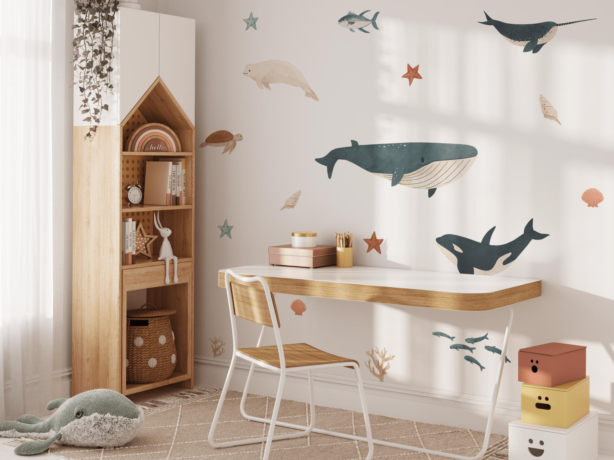 Study corner in a kid's room decorated with charming sea creature decals, accompanied by a stuffed dolphin and warm wooden furniture.