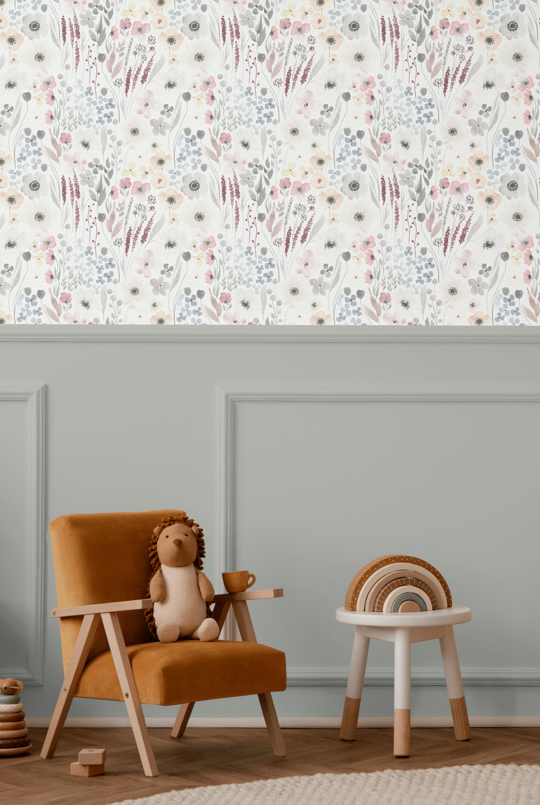 Children's playroom featuring the Vintage Anemones peel and stick wallpaper above a grey wainscoting, paired with a cozy armchair, wooden toys, and a plush toy, creating a warm and inviting environment