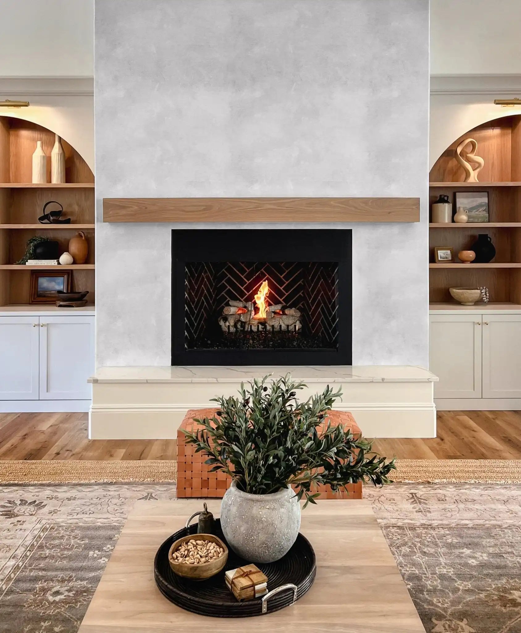 White limewash wallpaper on fireplace feature wall, paired with warm wood and modern built-in shelves