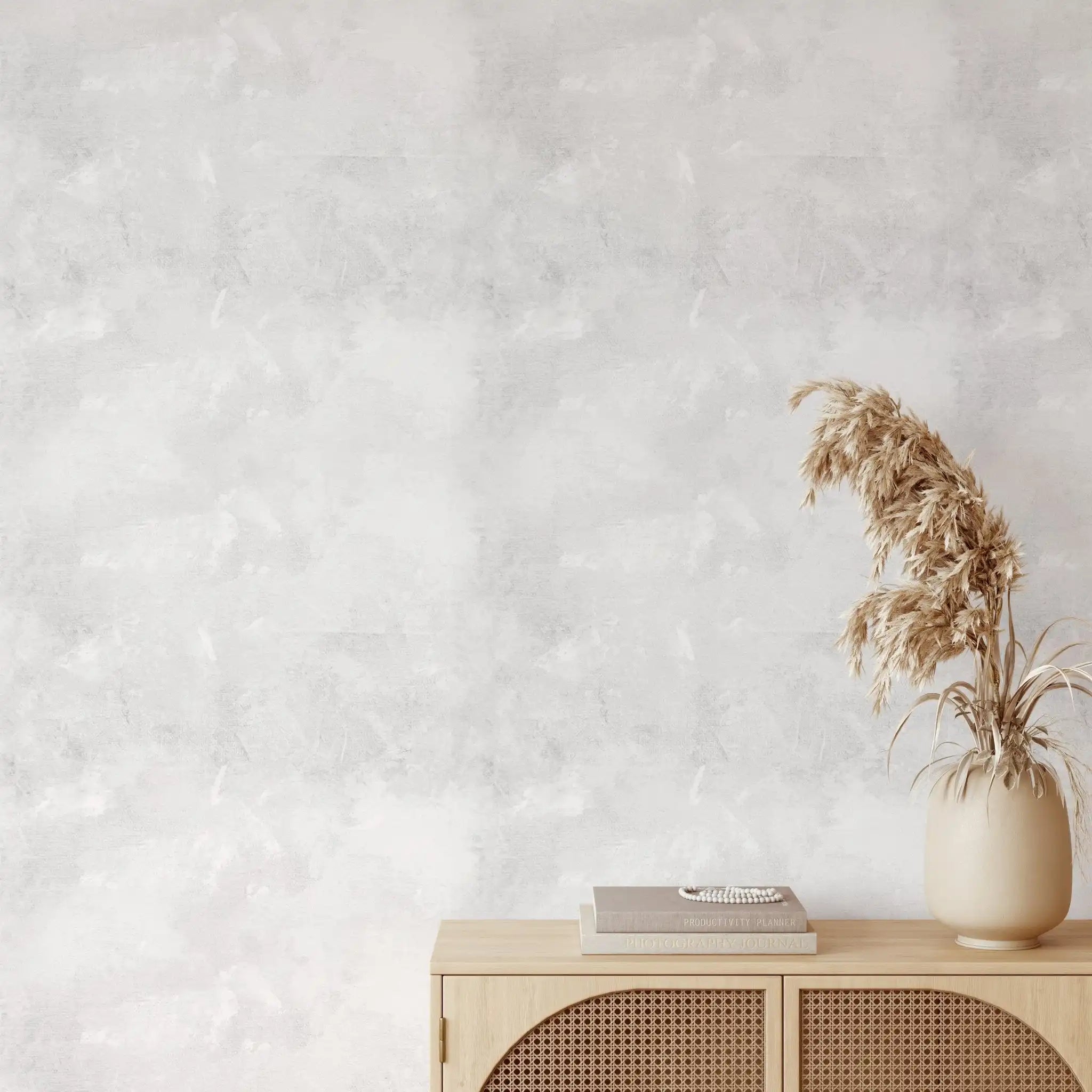 Subtle plaster-effect white wallpaper paired with rattan cabinet and dried florals in a soft minimalist room