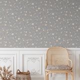 Elegant room featuring our Winter floral peel and stick wallpaper, paired with a traditional white wainscoting and a natural-toned wicker chair, creating a warm and inviting atmosphere with subtle floral patterns on a grey background