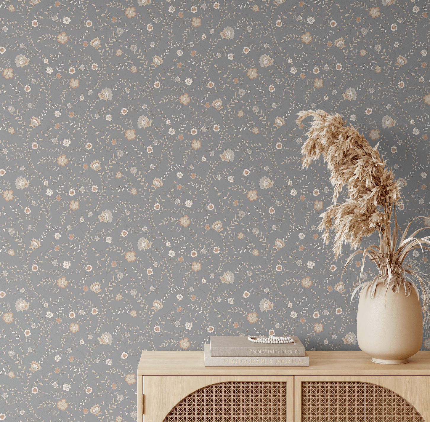 Styled room featuring our Winter floral peel and stick wallpaper, showcasing delicate patterns of flowers and leaves on a grey background, paired with a neutral-toned wooden sideboard and dried pampas grass in a vase