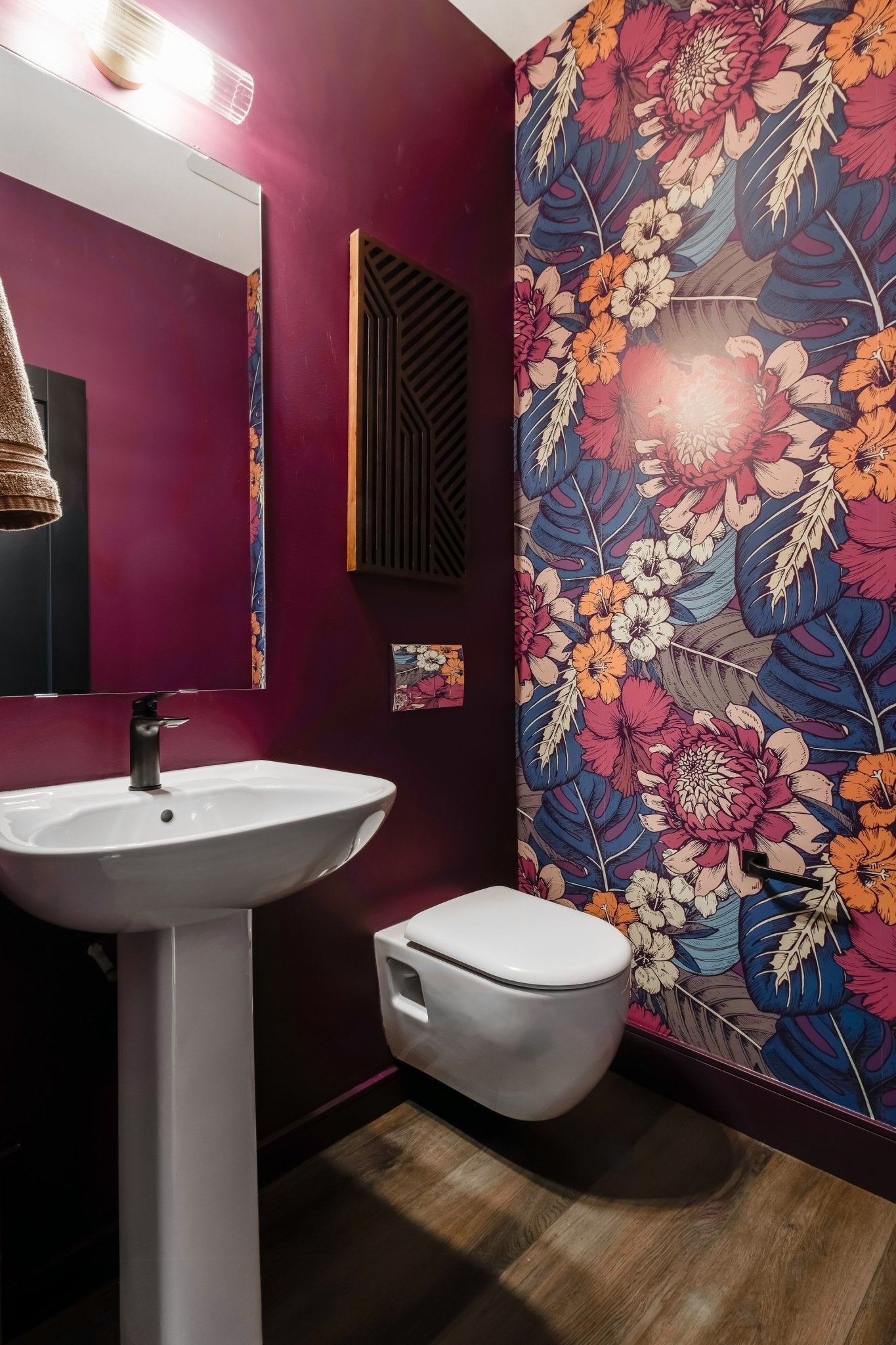 Vibrant wallpaper floral peel and stick wallpaper in a bathroom with red paint walls