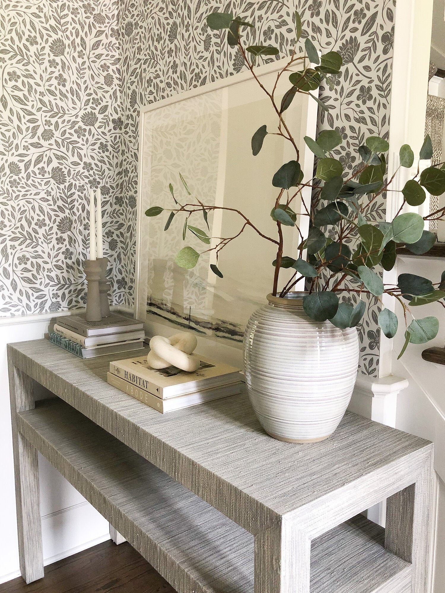 Peel and Stick wallpaper behind a decorative table with Potted plant and books