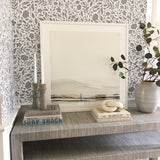 Table decor with books and decorated with grey and white peel and stick floral wallpaper