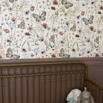 Vintage nursery with floral butterfly peel and stick wallpaper and purple accent walls